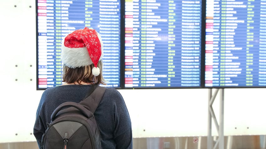 woman looking at airport departure board