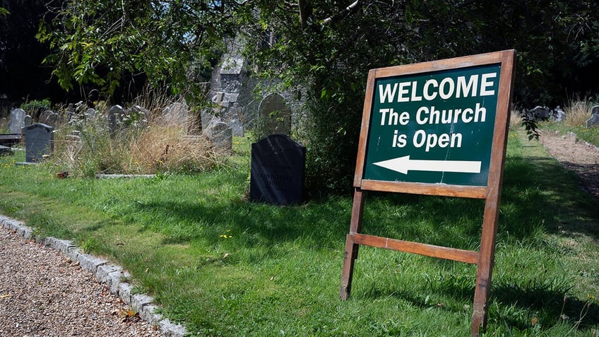 Sign reads "WELCOME The Church Is Open" with an arrow at St Mary's church in England