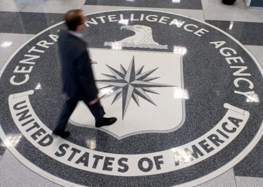 A man crosses the Central Intelligence Agency (CIA) seal in the lobby of CIA Headquarters