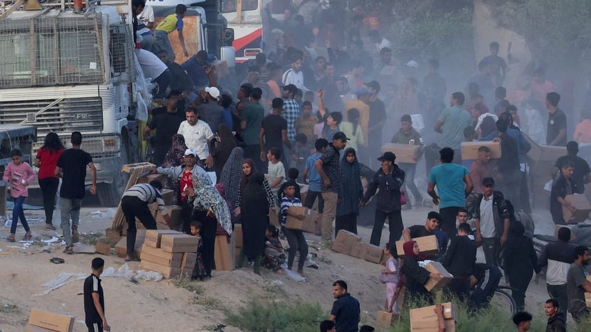 Palestinians climb onto trucks to grab aid that was delivered into Gaza through a U.S.-built pier, amid the ongoing conflict between Israel and the Islamist group Hamas, as seen from the central Gaza Strip.