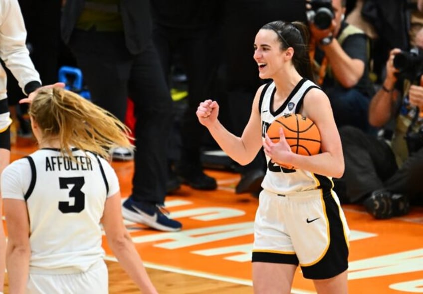 Iowa's Caitlin Clark, right, celebrates after the Hawkeyes beat Connecticut to advance to