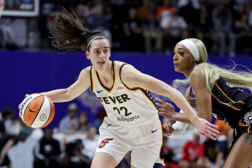 Caitlin Clark of the Indiana Fever dribbles against DiJonai Carrington of the Connecticut