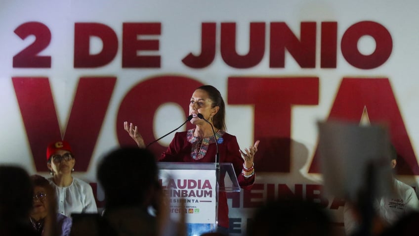 Presidential candidate of the ruling MORENA party Claudia Sheinbaum stands behind a podium and addresses a crowd during a campaign rally in Mexico City.