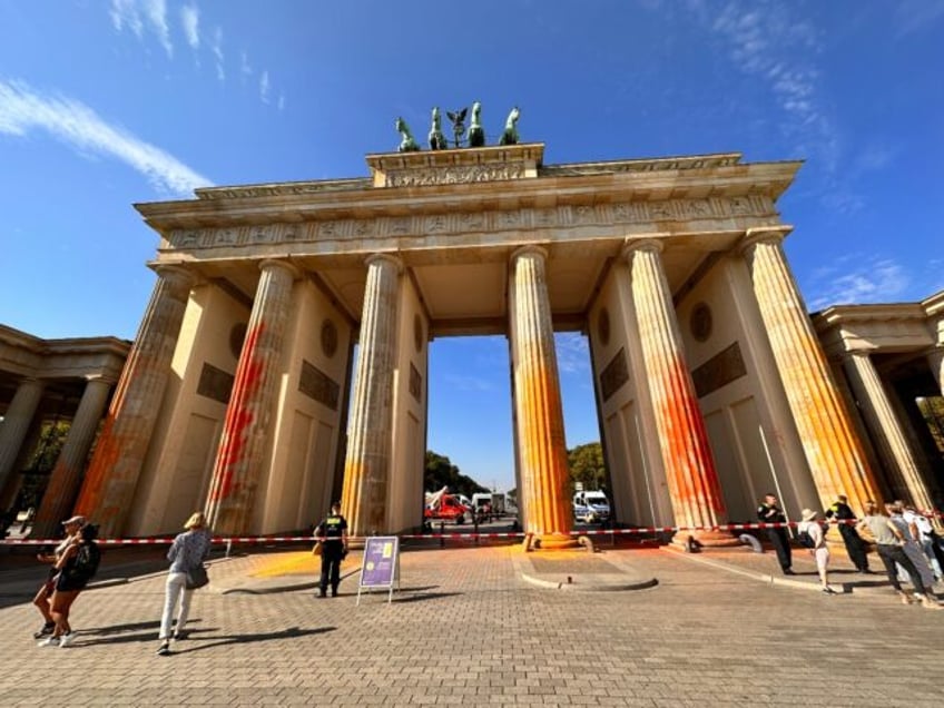 climate activists deface berlins brandenburg gate with orange paint