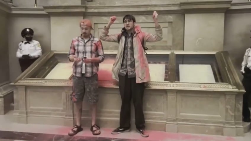 National Archives Rotunda evacuated after climate activists dump pink powder on case holding US Constitution