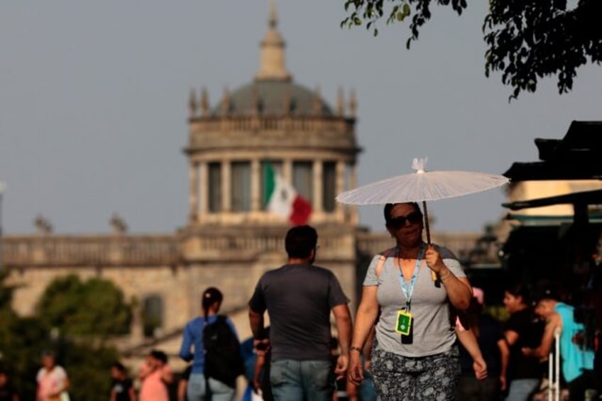 People protect themselves from the sun during a heat wave hitting the country, in Guadalaj