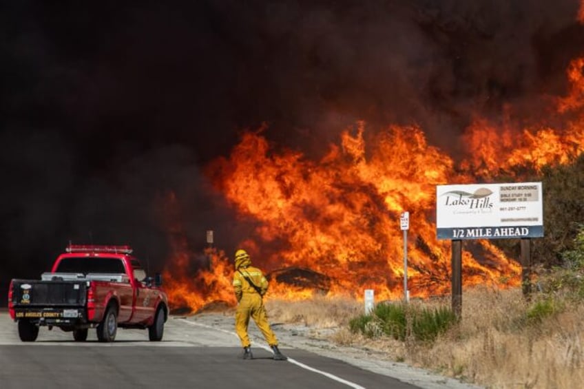 A firefighter backs up from the Hughes Fire in Los Angeles County, California on January 2