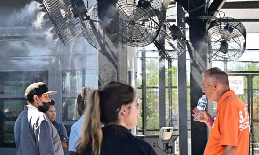 Security staff under cooling fans at Allegiant Stadium in Las Vegas on July 6, 2024 during