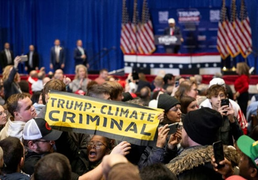 Climate protesters interrupt former US president and Republican presidential candidate Donald Trump as he speaks at a rally in Indianola, Iowa, on January 14, 2024, one day before the state's presidential caucus vote