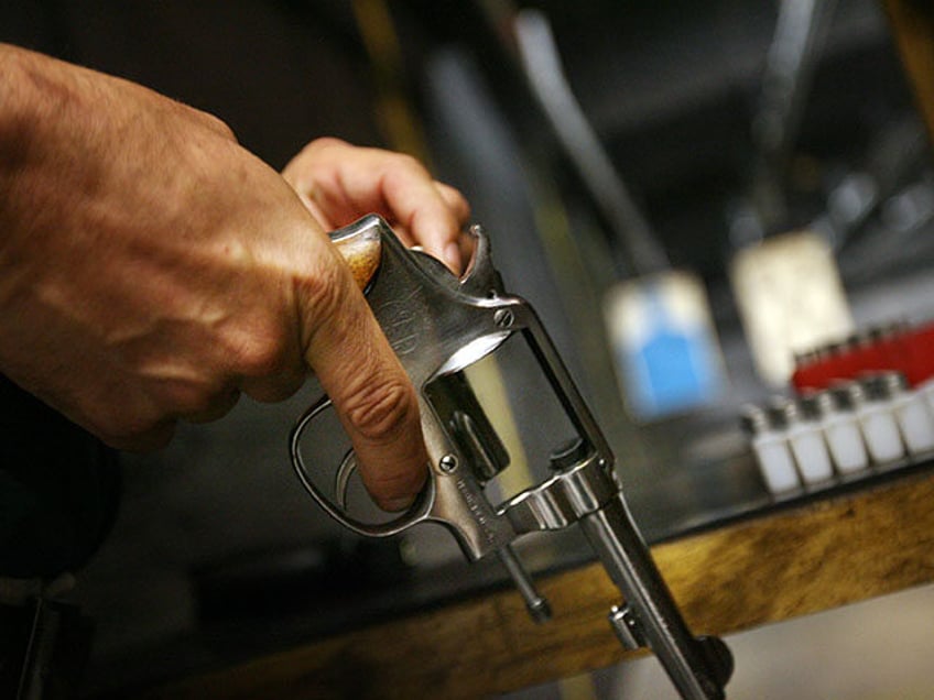 Scott Varner of Grapevine, TX, loads a .38 caliber Smith & Wesson hand gun June 26th at th