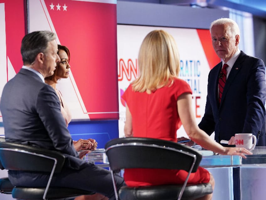 Democratic presidential hopeful former US vice president Joe Biden talks with moderators (