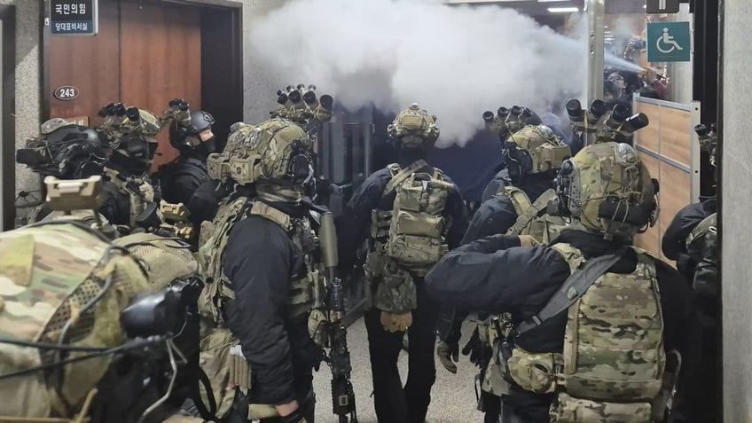 National Assembly employees spray a fire extinguisher towards soldiers at the National Assembly in Seoul, South Korea.