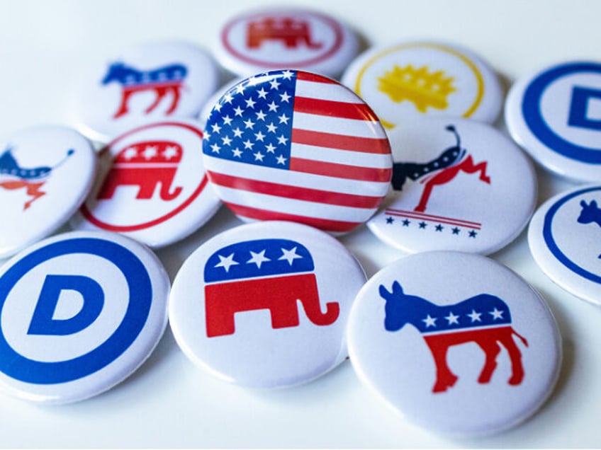 A pile of political buttons sitting on top of a table: Democratic Party and Republican Par