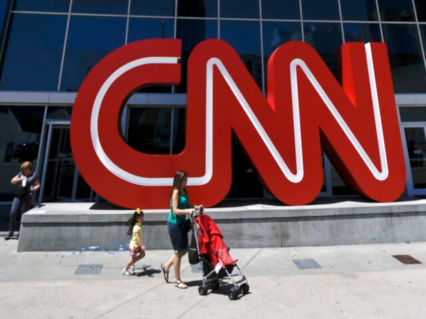 Pedestrians pass the entrance to CNN headquarters, Tuesday, Aug. 26, 2014, in Atlanta. The