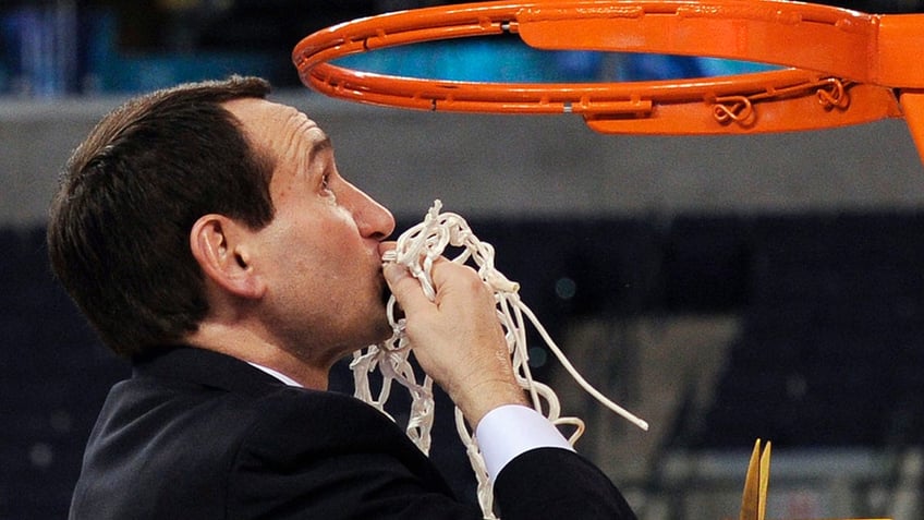 Duke head coach Mike Krzyzewski kisses the net after cutting it down following Duke's 61-59 win over Butler in the men's NCAA Final Four college basketball championship game, April 5, 2010, in Indianapolis.