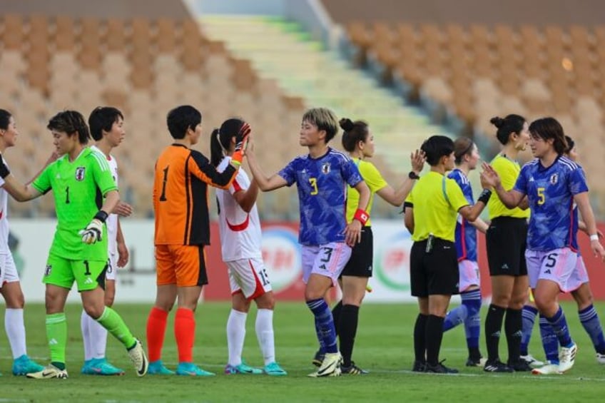 Players shake hands after North Korea and Japan drew 0-0 in the first leg of their women's