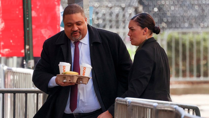 Manhattan DA Alvin Bragg holding coffee and donuts