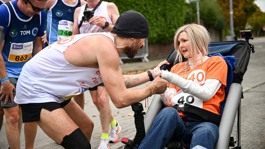 Colin Farrell wears white tank top and shorts to run marathon with Emma Fogarty.