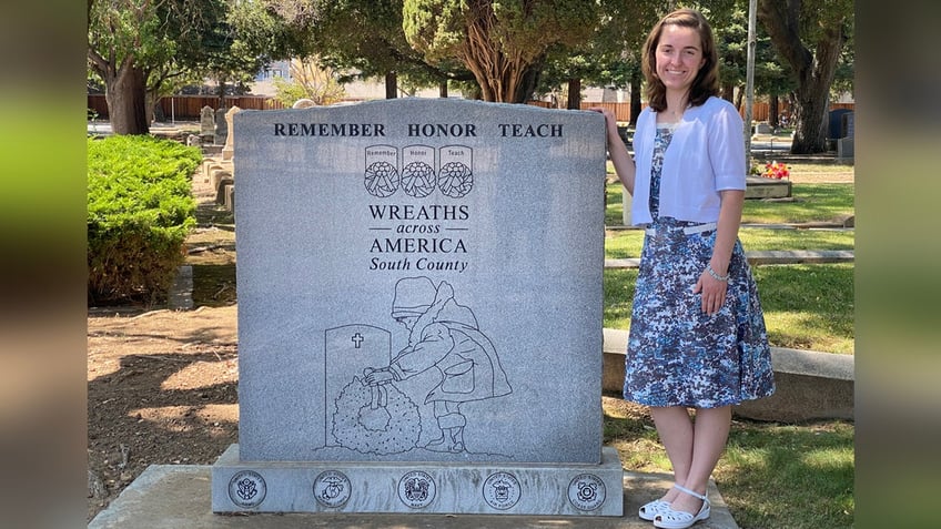 Woman next to Wreaths Across America monument.