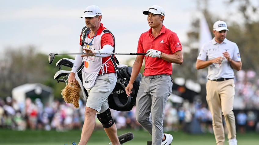 Collin Morikawa hands his driver to caddie Jonathan "JJ" Jakovac