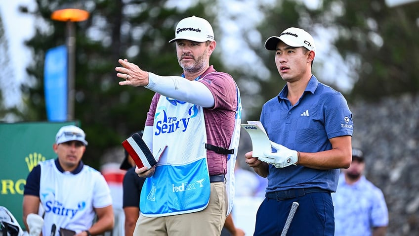 Collin Morikawa speaks with his caddie Jonathan Jakovac 