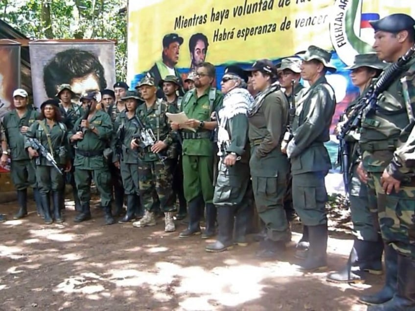 This TV grab taken from YouTube and released on August 29, 2019, shows former senior commanders of the dissolved FARC rebel army group in Colombia, Ivan Marquez (C) and fugitive rebel colleague, Jesus Santrich (wearing sunglasses), on an undisclosed location announcing that they are taking up arms again along with other guerrillas who have distanced themselves from a peace accord signed with the government in 2016.