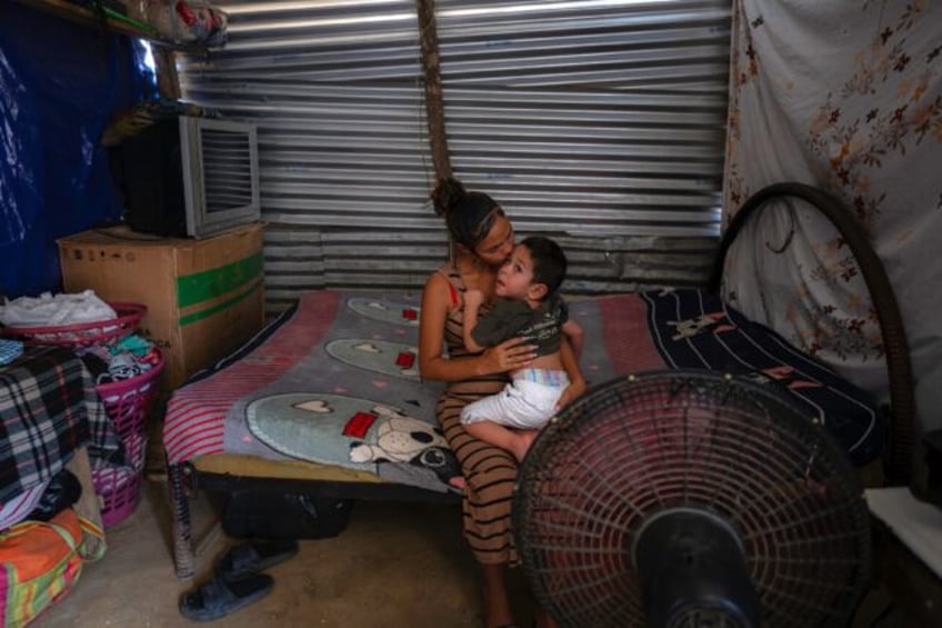 Venezuelan Astrid kisses her son Luis at their home in La Pista migrant camp in Maicao, La