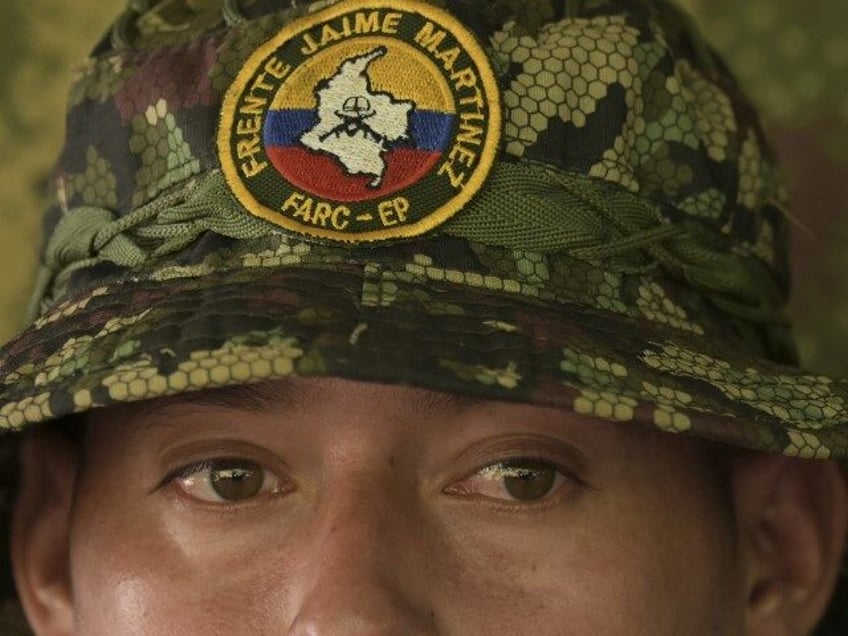 A guerrilla fighter from the FARC “dissidence” Jaime Martinez stands guard as commande