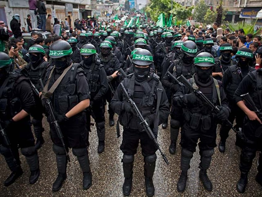 In this Dec. 14, 2014, file photo, masked Palestinian gunmen of the Hamas militant group hold weapons during a rally to commemorate the 27th anniversary of the group in Gaza City. Amnesty International on Wednesday, May 27, 2015, accused the militant group of abducting, torturing and killing Palestinians during the war in the Gaza Strip summer 2014, saying some of the actions amount to war crimes. (AP Photo/Khalil Hamra, File)