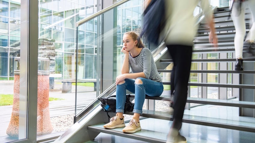 Girl on staircase looking sad. 