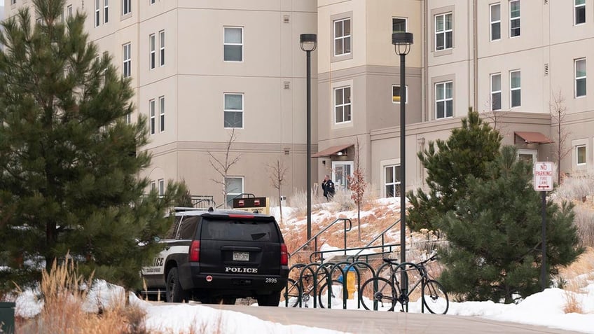 A police car parked in front of the dorm