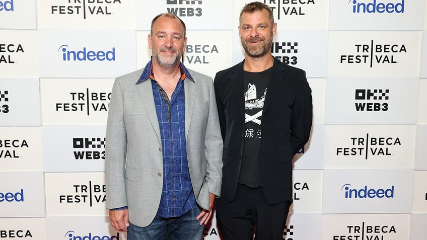 Trey Parker and Matt Stone posing on a red carpet.