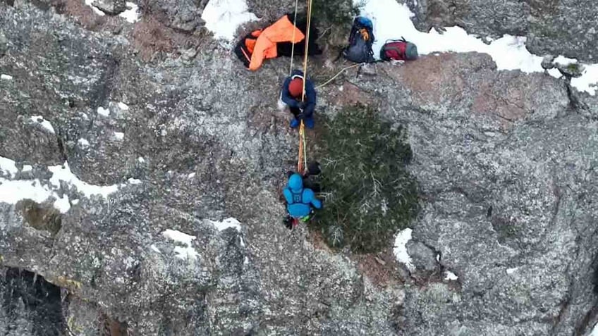 rescuers lowering down ledge