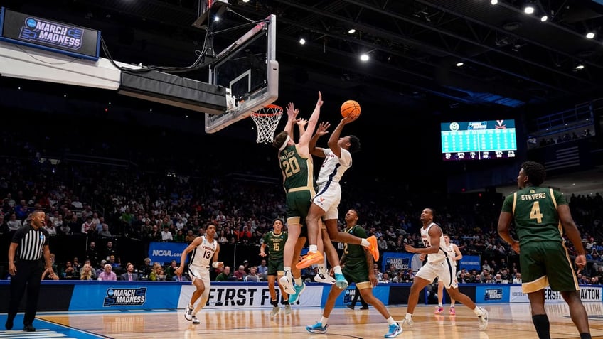 Virginia guard Reece Beekman, center right, shoots against Colorado State's Joe Palmer