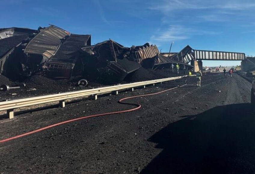 colorado train derails spilling train cars and coal onto a highway and trapping a semi truck driver