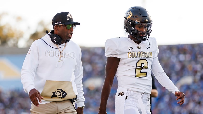 Deion Sanders walks with Shedeur Sanders 