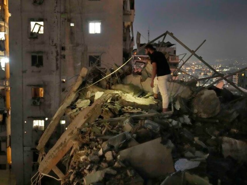 A man inspects a destroyed building that was hit by an Israeli airstrike in the southern s