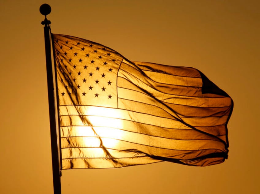 BAYONNE, NJ - JULY 21: The sun sets behind an American flag at the Tear Drop 9/11 Memorial