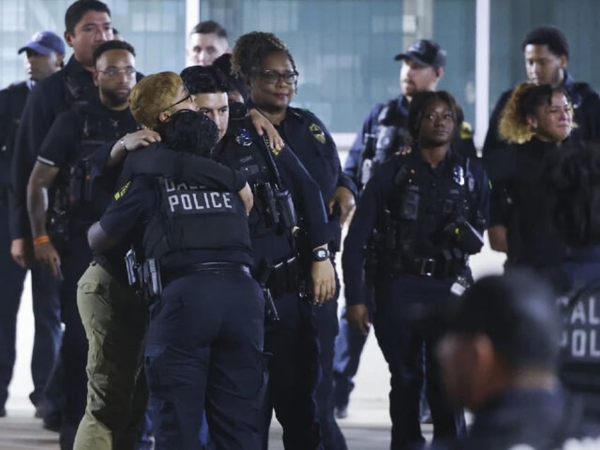 Dallas police officers gather outside the hospital following the shooting death of a fello