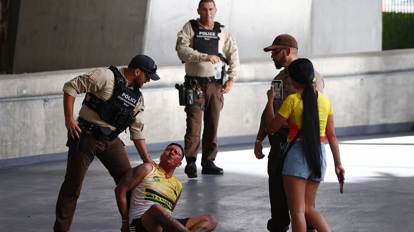 Officers detain a fan at the stadium