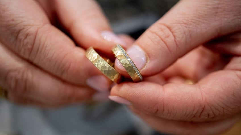 hands holding gold rings