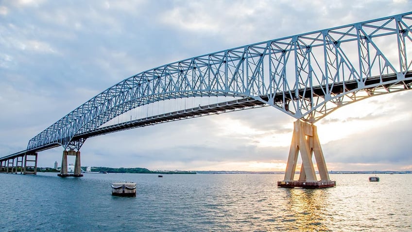 Looking west, the Francis Scott Key Bridge glistens in the sunset