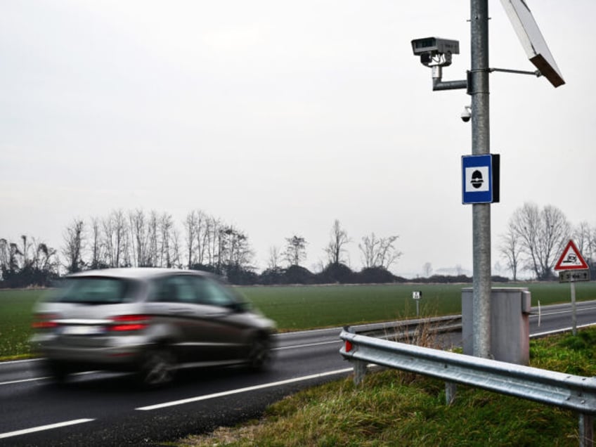 A car rides past a speed camera on January 26, 2024 on a road of Lagnasco, northwestern Italy. Hailed by exasperated motorists or condemned as a vigilante who risks lives, a saboteur known as "Fleximan" has been destroying speed cameras across northern Italy, sparking a national debate. (Photo by Marco …