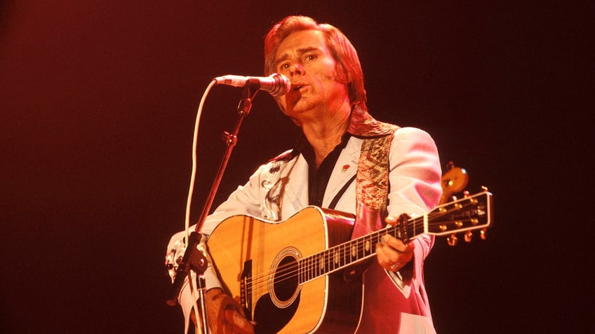 George Jones performing on stage with a guitar