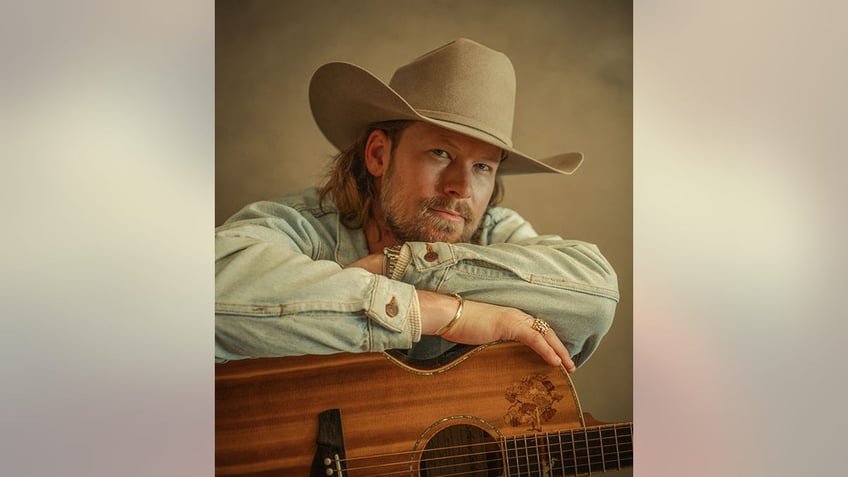 Brian Kelley posing with his guitar