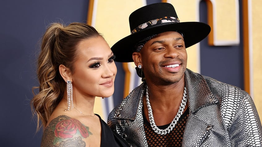 Jimmie Allen and wife Alexis Gale pose for photos