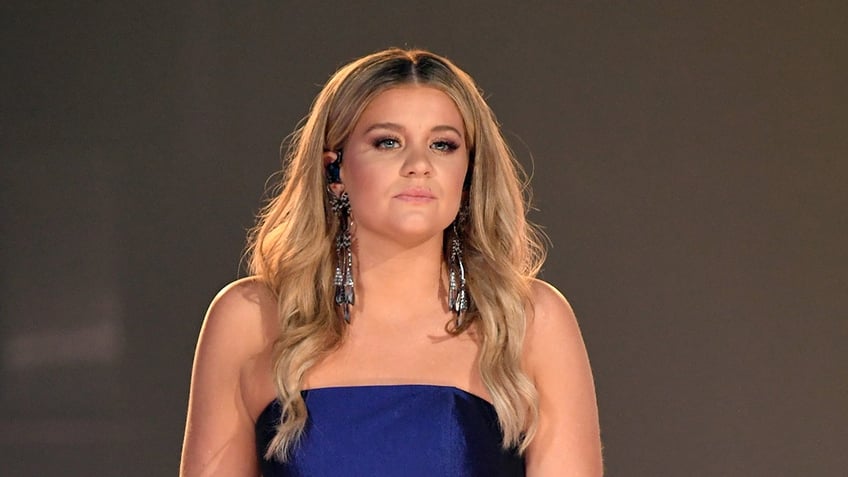 Country singer Lauren Alaina performs in blue dress.