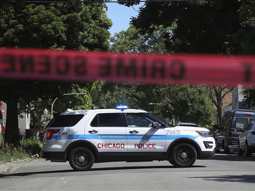 Police tape marks off a Chicago street as officers investigate the scene of a fatal shooti