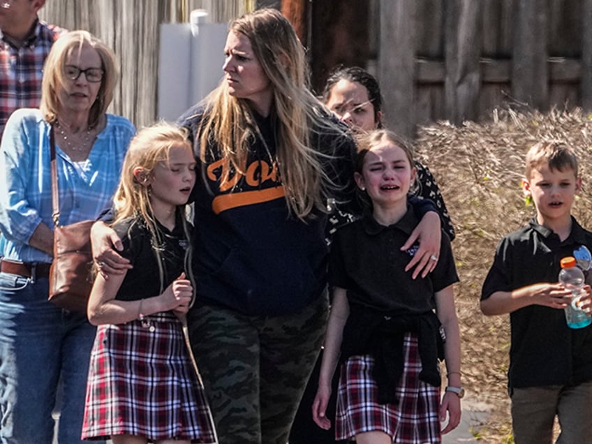 Children and a woman depart the reunification center at the Woodmont Baptist church after a deadly school shooting, Monday, March 27, 2023, in Nashville, Tenn. (AP Photo/John Bazemore)