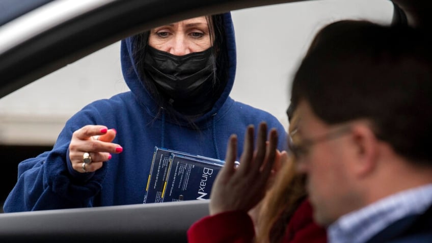 Youngstown City Heath Department worker Kathy Johnson talks with drivers before giving them at-home COVID-19 test kits during a distribution event, Thursday, Dec. 30, 2021, in Youngstown, Ohio. (AP Photo/David Dermer)